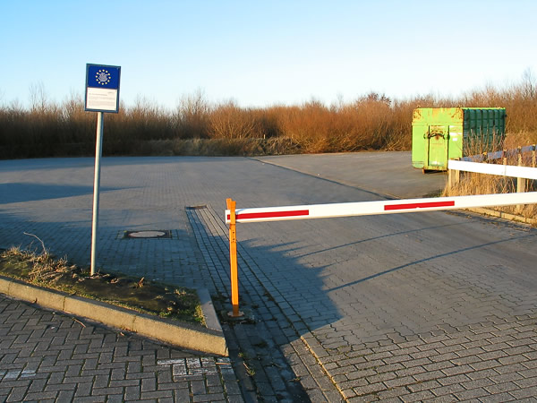 Platz mit Schranke und Müllcontainer